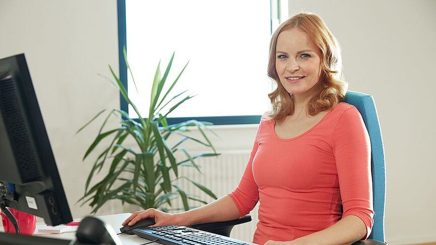 a woman in an ergonomic workplace relieves her back pain